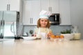 Chef kid boy baking on the kitchen. Child chef cook prepares food at kitchen. Kids cooking. Teen boy with apron and chef Royalty Free Stock Photo