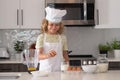 Chef kid boy baking on the kitchen. Child chef cook prepares food at kitchen. Kids cooking. Teen boy with apron and chef Royalty Free Stock Photo