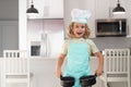 Chef kid boy baking on the kitchen. Child chef cook prepares food at kitchen. Kids cooking. Teen boy with apron and chef Royalty Free Stock Photo