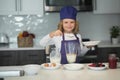 Chef kid preparing tasty food at kitchen. Child making tasty delicious. little boy in chef hat and an apron cooking in Royalty Free Stock Photo