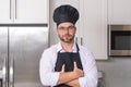 Chef on kitchen. Professional chef man in uniform on kitchen. Bearded chef, cook or baker. Male chef over kitchen