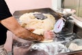 Chef kneading a batch of fresh pizza dough