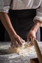 A chef is kneading dough using eggs, kitchen dark background, professional photography light Royalty Free Stock Photo