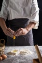 A chef is kneading dough using eggs, kitchen dark background, professional photography light Royalty Free Stock Photo