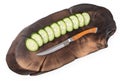 Chef knife on oak cutting board with slices of cucumber isolated on a white, top view, close up Royalty Free Stock Photo