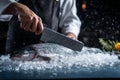 A chef with a knife slices through a fresh fish resting on a bed of ice. The kitchen setting is vibrant, with water droplets in Royalty Free Stock Photo