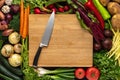 Chef Knife on Wooden Chopping Board with Fresh Vegetables Background. Vegetarian Raw Food. Royalty Free Stock Photo