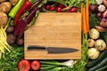 Chef Knife on Wooden Chopping Board with Fresh Vegetables Background. Vegetarian Raw Food. Royalty Free Stock Photo