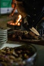 Chef with latex gloves cutting roast meat on board. Royalty Free Stock Photo