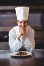 Chef leaning on the counter with a dish Royalty Free Stock Photo