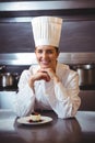 Chef leaning on the counter with a dish Royalty Free Stock Photo