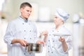 chef looks at a cooked dish of a young cook with reproach