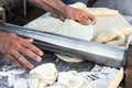 Chef making dough pastry sheeter at bakery Baker forming shaping dough rolled pastry metal work table closeup hands process of pre Royalty Free Stock Photo