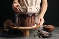 Chef making fresh delicious chocolate cake at grey table Royalty Free Stock Photo