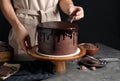 Chef making fresh delicious chocolate cake at grey table Royalty Free Stock Photo