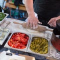 Chef making pita bread for falafel roll outdoor on street stall.