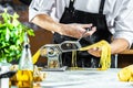 Chef making spaghetti noodles with pasta machine on kitchen table with some ingredients around Royalty Free Stock Photo