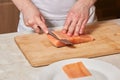Chef making sushi rolls. Cutting salmon fish on wooden board Royalty Free Stock Photo