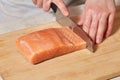 Chef making sushi rolls. Cutting salmon fish on wooden board Royalty Free Stock Photo