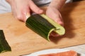 Chef making sushi rolls. Cutting cucumber Royalty Free Stock Photo