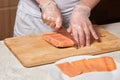 Chef making sushi rolls. Cutting salmon fish on wooden board Royalty Free Stock Photo