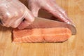Chef making sushi rolls. Cutting salmon fish on wooden board Royalty Free Stock Photo