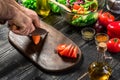 Chef man cooking in the kitchen. Man`s hand cuts carrot on a wooden board Royalty Free Stock Photo