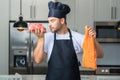 Chef man preparing fresh natural meal at kitchen home indoors. Handsome cheerful man preparing raw fish and meat, salmon Royalty Free Stock Photo