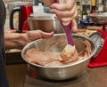 Chef mixes cocoa, flour with the rest of the ingredients in bowl for making pie Royalty Free Stock Photo