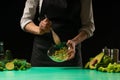 The chef mixes fresh vegetables, cooking fresh green fresh dietically, detox. Healthy and clean food, diet and sport. Background Royalty Free Stock Photo