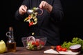 Chef neatly mixing fresh summer salad in a bowl. Cooking process