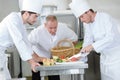Chef overseeing trainees prepping vegetables Royalty Free Stock Photo