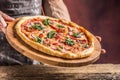 Chef and pizza. Chef offering pizza in hotel or restaurant Royalty Free Stock Photo