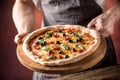 Chef and pizza. Chef offering pizza in hotel or restaurant Royalty Free Stock Photo