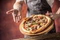 Chef and pizza. Chef offering pizza in hotel or restaurant Royalty Free Stock Photo