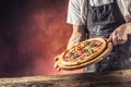 Chef and pizza. Chef offering pizza in hotel or restaurant