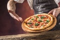 Chef and pizza. Chef offering pizza in hotel or restaurant Royalty Free Stock Photo