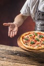 Chef and pizza. Chef offering pizza in hotel or restaurant Royalty Free Stock Photo