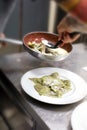 Chef plating up a serving of ravioli pasta