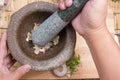 Chef pound pepper and garlic with pestle on mortar Royalty Free Stock Photo