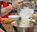 The chef is pouring flour into bowl for making cherry pie, clafoutis. Step by step recipe