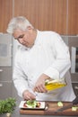 Chef Pouring Olive Oil Over Salad