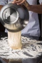 Chef pouring out dough from a mixing bowl