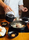 Chef is pouring Shabu sauce mix with fried onion, scallion and beef fat before boiling Wagyu beef and Kurobuta pork Royalty Free Stock Photo