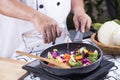 Chef pouring soup to the pan