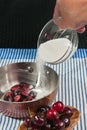 Chef pouring sugar into cherries jubilee preparation