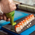 Chef pouring wasabi to the sushi table