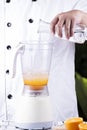 Chef pouring water in to electric Blender Royalty Free Stock Photo