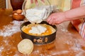 Chef pours batter into pan to prepare apricot cheesecake