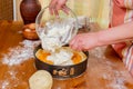 Chef pours batter into pan to prepare apricot cheesecake